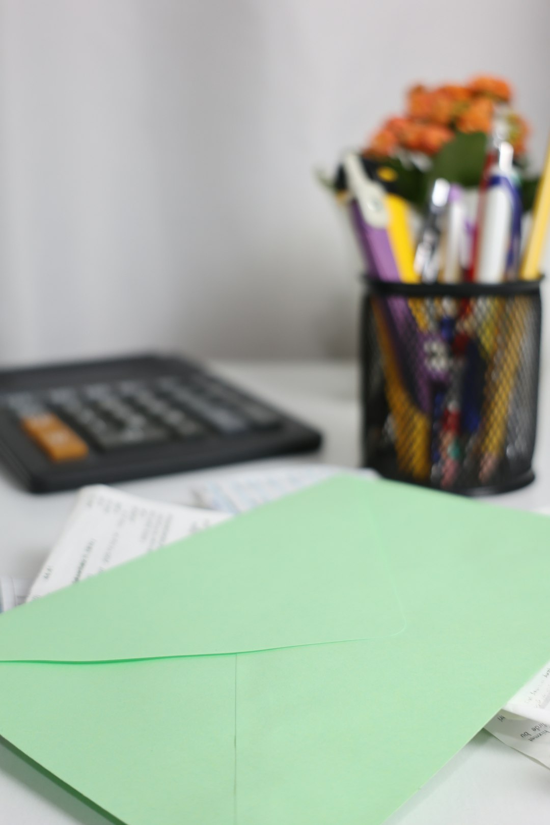 a-green-envelope-rests-on-papers-near-a-calculator-akwdzmpp0qc